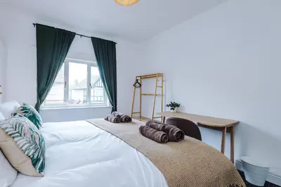 a bedroom with a large white bed with a desk at 2 Bed Apartment ,Sea Views in Blackpool