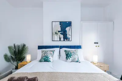 a bedroom with a bed with white sheets and pillows at 2 Bed Apartment ,Sea Views in Blackpool