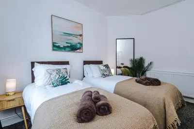 two beds with brown towels on them in a bedroom at 2 Bed Apartment ,Sea Views in Blackpool