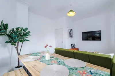 a living room with a table and a green couch at 2 Bed Apartment ,Sea Views in Blackpool