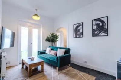 a living room with a green couch and a table at 2 Bed apartment, sleeps up to 5 in Blackpool