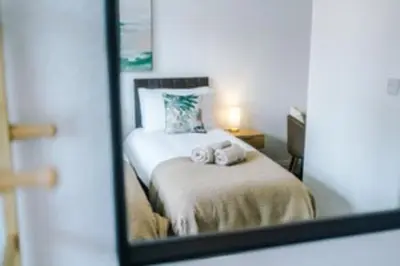 a mirror reflection of a bed with towels on it at 2 Bed apartment, sleeps up to 5 in Blackpool