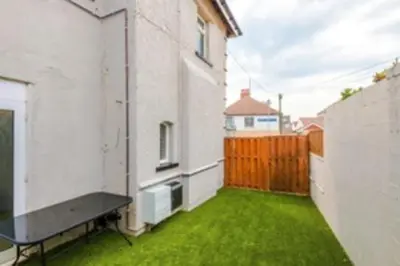 a backyard with a green yard with a fence at 2 Bed apartment, sleeps up to 5 in Blackpool
