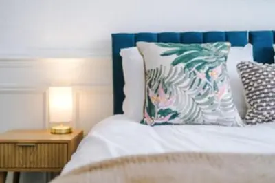 a bed with a blue headboard and a pillow on it at 2 Bed apartment, sleeps up to 5 in Blackpool
