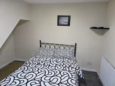 a bedroom with a bed with a black and white comforter at 2wayz Home in Liverpool