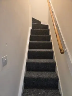 a staircase with black carpeting and a stair case at 2wayz Home in Liverpool