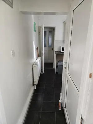 a hallway of a bathroom with a toilet and a sink at 2wayz Home in Liverpool