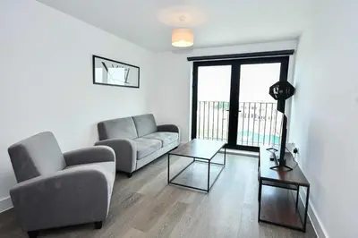 a living room with two couches and a table at Modern & Convenient 2 Bedroom Liverpool Apartment in Liverpool