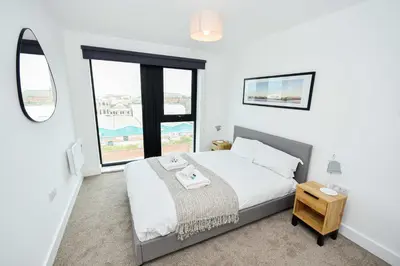 a bedroom with a bed and a large window at Modern & Convenient 2 Bedroom Liverpool Apartment in Liverpool