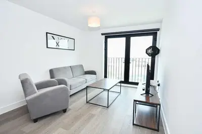 a living room with a couch and a table at Modern & Convenient 2 Bedroom Liverpool Apartment in Liverpool