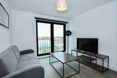 a living room with a couch and a flat screen tv at Modern & Convenient 2 Bedroom Liverpool Apartment in Liverpool