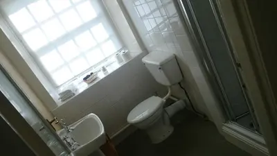 a bathroom with a toilet and a sink and a window at The Silverdale Hotel in Silverdale