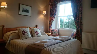 a bedroom with a bed with towels on it at The Silverdale Hotel in Silverdale