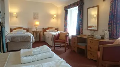 a hotel room with two beds and a mirror at The Silverdale Hotel in Silverdale