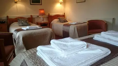 a room with three beds with towels on them at The Silverdale Hotel in Silverdale