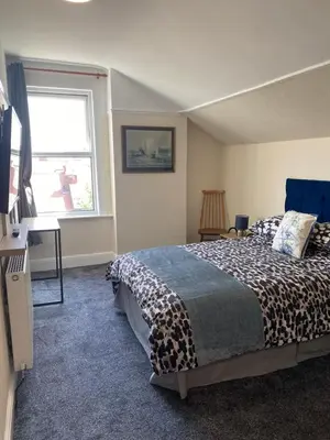 a bedroom with a bed and a window at Superior, spacious apartment in New Brighton, near Liverpool in New Brighton