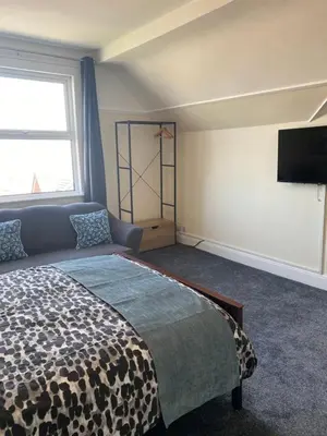 a bedroom with a bed and a flat screen tv at Superior, spacious apartment in New Brighton, near Liverpool in New Brighton