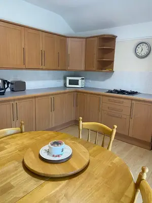 a kitchen with a wooden table with a cup on it at Superior, spacious apartment in New Brighton, near Liverpool in New Brighton