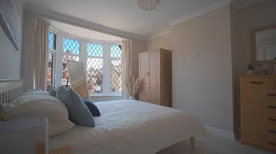 a bedroom with a large bed and a window at Spacious 3-Bed Home - Central Blackpool in Blackpool