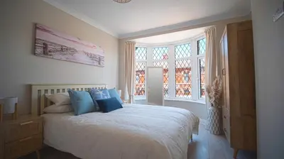 a bedroom with a large bed with blue pillows at Spacious 3-Bed Home - Central Blackpool in Blackpool