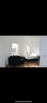 a living room with a couch and two windows at Lane Stay in Liverpool