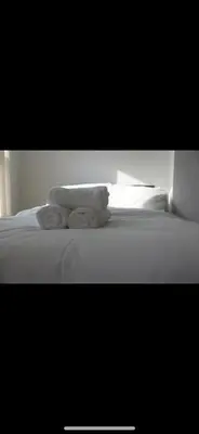 a white bed with two towels on top of it at Lane Stay in Liverpool