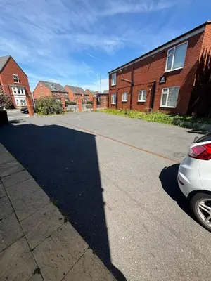 a car parked in a parking lot next to a brick building at #47 Cozy Anfield Near Stadium Free On-Site Parking in Liverpool