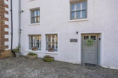 a white house with a door and two windows at 4 Bed in Cartmel oc-d31802 in Cartmel