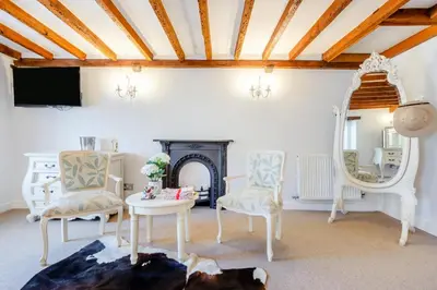 a living room with a fireplace and two chairs and a mirror at 4 Bed in Cartmel oc-d31802 in Cartmel