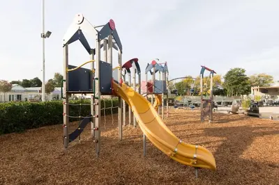 a playground with a yellow slide at a park at Miarlo Lodge Rydal Haven Lakeland in Flookburgh