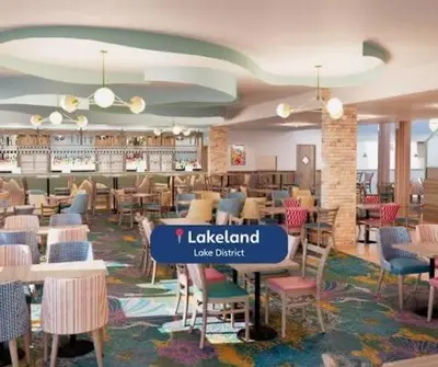 a restaurant with chairs and tables and a library at Miarlo Lodge Rydal Haven Lakeland in Flookburgh