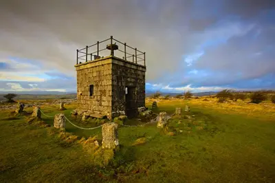 an old stone tower in a field with a fence at Corner Beech House in Grange Over Sands