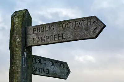 a wooden sign with two street signs on a pole at Corner Beech House in Grange Over Sands