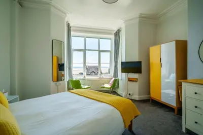 a bedroom with a large bed and a window at Corner Beech House in Grange Over Sands