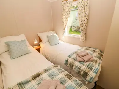 two beds in a small room with a window at Barney's Retreat - Docker Park Farm in Carnforth