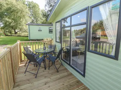 a deck with a table and chairs and a grill at Barney's Retreat - Docker Park Farm in Carnforth