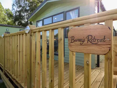 a wooden fence with a sign on a deck at Barney's Retreat - Docker Park Farm in Carnforth