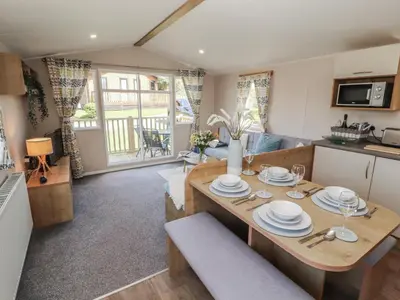 a kitchen and living room with a table and chairs at Barney's Retreat - Docker Park Farm in Carnforth