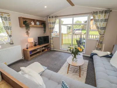 a living room with a couch and a tv at Barney's Retreat - Docker Park Farm in Carnforth