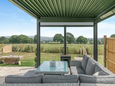 a covered patio with a couch and a table at Barn Owl Lodge - Uk49903 in Appley Bridge