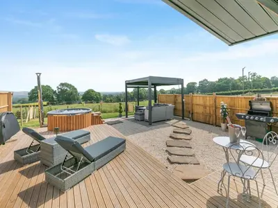 a patio with a grill and a barbecue on a deck at Barn Owl Lodge - Uk49903 in Appley Bridge