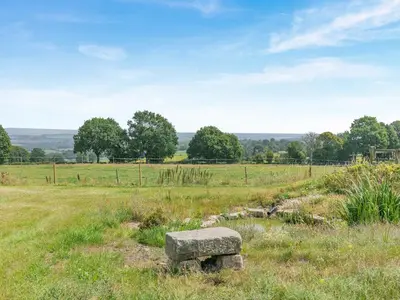 a stone bench sitting in a field of grass at Barn Owl Lodge - Uk49903 in Appley Bridge