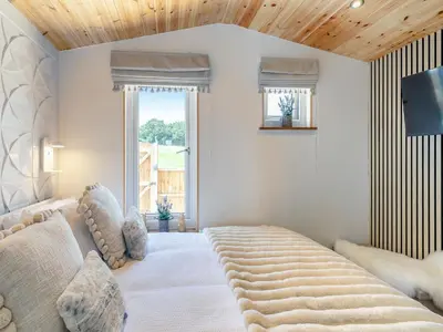 a bedroom with a large bed with a wooden ceiling at Barn Owl Lodge - Uk49903 in Appley Bridge