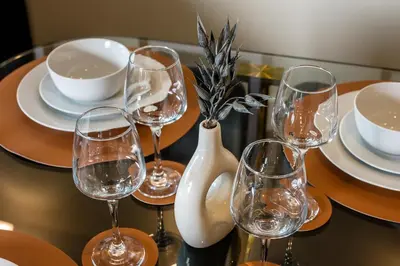 a table with wine glasses and plates and a vase at Spectacular Central Apartment Free Parking Sleep 7 in Liverpool