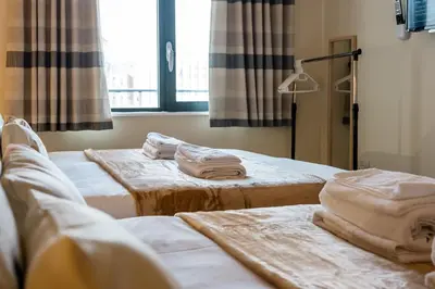 two beds in a room with towels on them at Spectacular Central Apartment Free Parking Sleep 7 in Liverpool