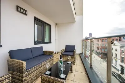 a balcony with two chairs and a couch on it at Spectacular Central Apartment Free Parking Sleep 7 in Liverpool