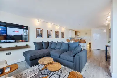 a living room with a blue couch and a flat screen tv at Spectacular Central Apartment Free Parking Sleep 7 in Liverpool