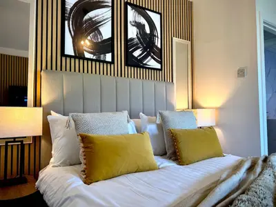 a bedroom with a large white bed with yellow pillows at Keswick Hot Tub Family House in Lytham St Annes