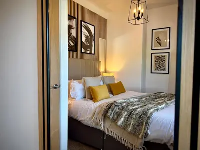 a bedroom with a bed with yellow pillows at Keswick Hot Tub Family House in Lytham St Annes