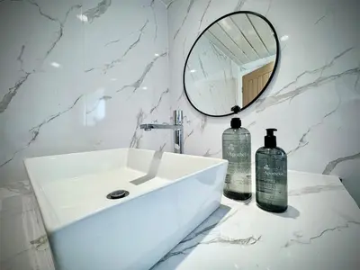 a white bathroom with a sink and a mirror at Keswick Hot Tub Family House in Lytham St Annes